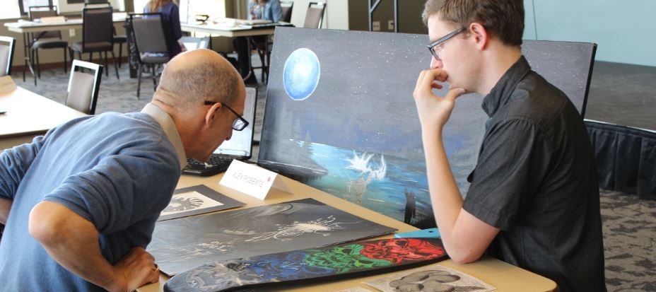 A student and local artist discuss his painting on Portfolio Day at Parker Arts.