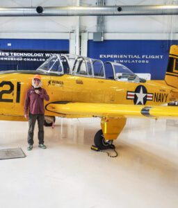 India Wood poses in front of a vintage yellow airplane at Wings Over the Rockies